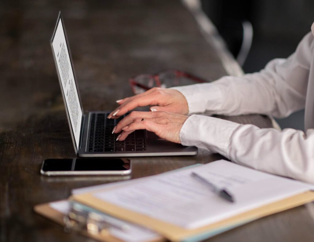 Author working on a manuscript using a laptop for professional book writing and editing services