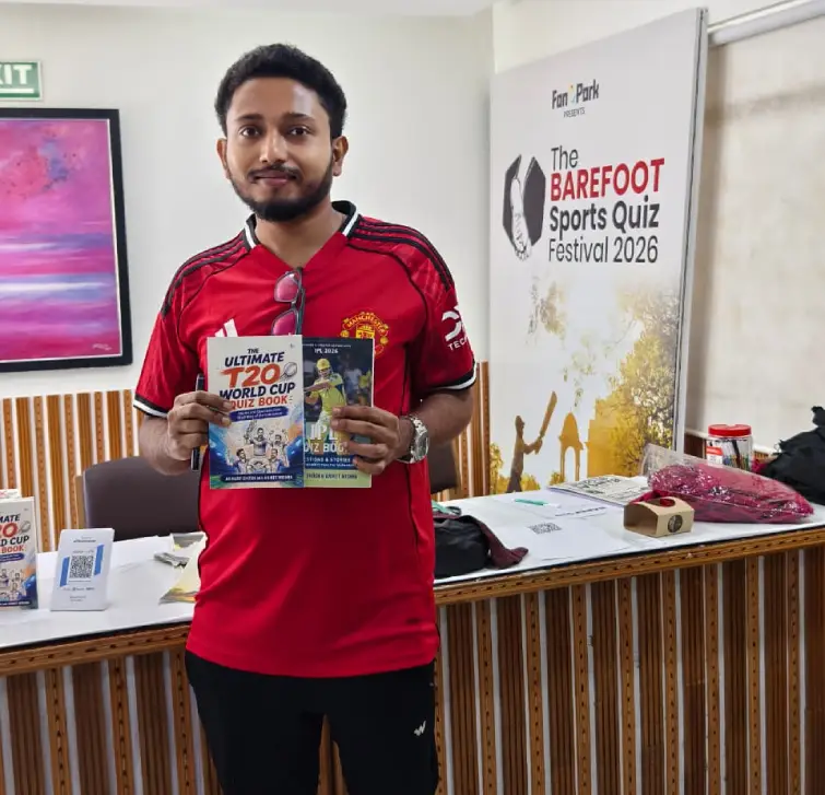 Reader holding Blue Pencil sports quiz books at Barefoot 2026
